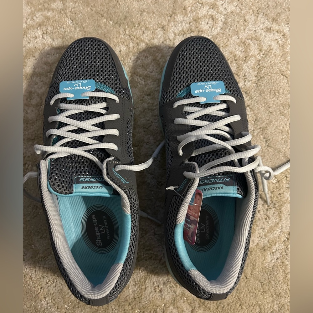 NWT Skechers women shape up tennis shoes with two pairs of laces. Never worn.